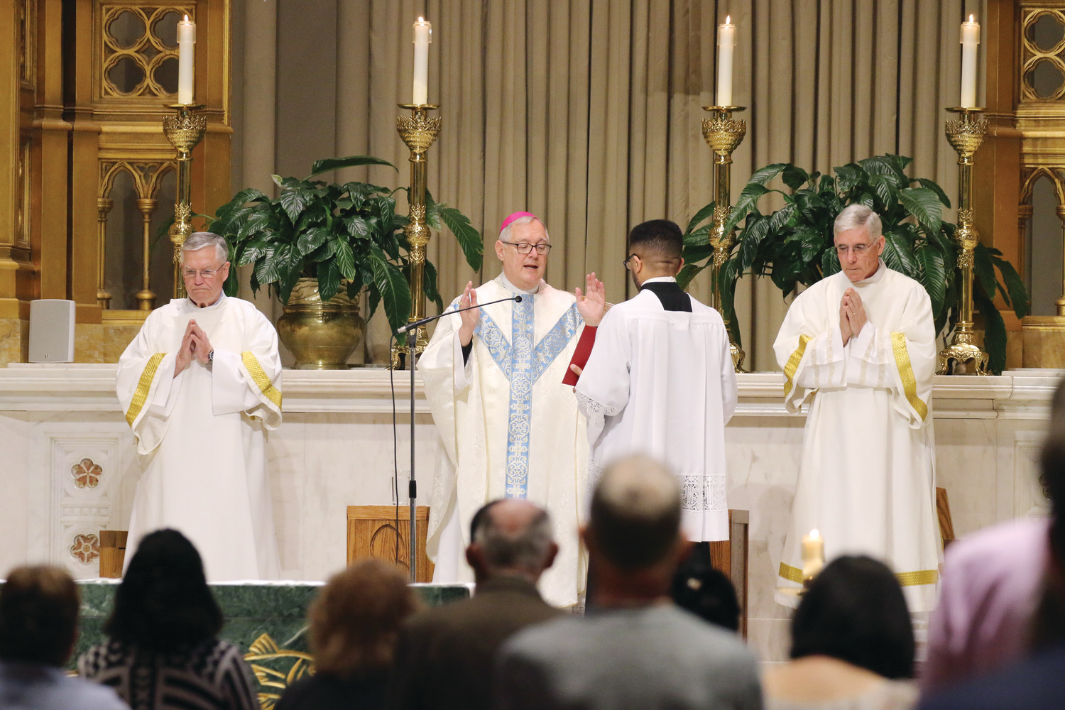 Bishop Thomas J. Tobin celebrates Mass on Monday, May 21, recognizing the inaugural feast in honor of Mary, Mother of the Church. Deacons James Walsh, left, and Noel Edsall assisted.